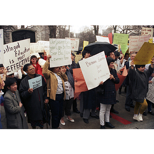 Demonstrators hold signs in favor of bilingual education in schools at a rally held outside the Massachusetts State House