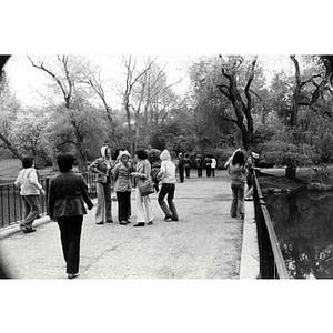 Several women converse while standing on a bridge