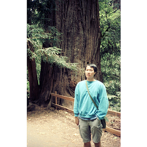 Chinese Progressive Association member stands on a hiking path in an unidentified forest