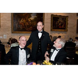 Joseph Aoun converses with two seated men at his inauguration celebration