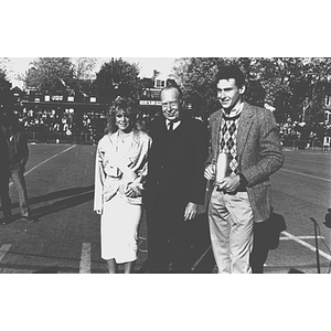 President Ryder stands with the 1986 Homecoming Queen and Mayor of Huntington Avenue on the football field