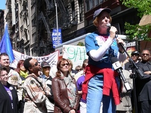 Cindy Sheehan speaking during the march opposing the War in Iraq (Susan Sarandon in the background center, and Jesse Jackson, right)