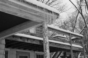 Icicles hanging from the eave of a house after a late-winter snow