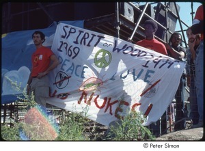 MUSE concert and rally: MUSE staff members holding banner in front of rally stage that reads, 'spirit of woods, peace love, no nukes'