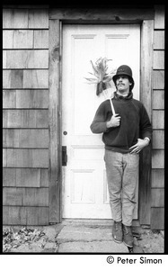 Elliot Blinder wearing an old police helmet and standing at the house door, holding a spatula, Packer Corners commune