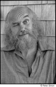 Ram Dass at typewriter: Portrait of Ram Dass winking