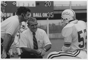Bob Pickett and Dick MacPherson talking with unidentified football player