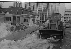 Construction equipment in front of car buried in snow on Cambridge Street