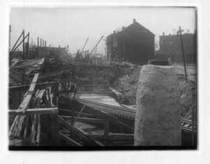 View of railroad tracks showing wood beams and buildings