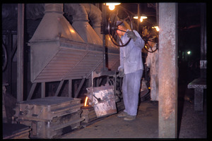 Shanghai tractor building factory: worker pouring iron into mould