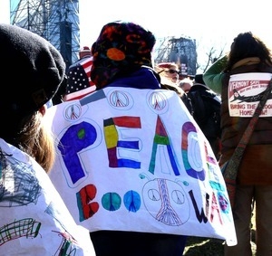 Woman among the protesters on the National Mall, marching against the War in Iraq and wearing a banner reading 'Peace: boo war'