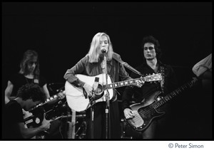 Joni Mitchell performing at the Harvard Square Theater, Cambridge, with the Rolling Thunder Revue