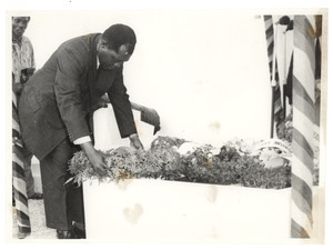 Unidentified man lays a wreath at the graveside of W. E. B. Du Bois