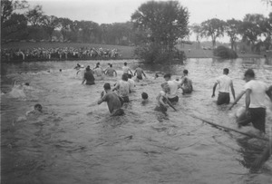 Rope pull participants wade through campus pond