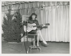 Young woman playing guitar during holiday play