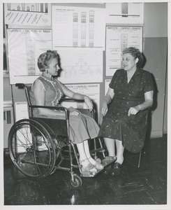 Two women, one in a wheelchair, in conversation at an administrators training group