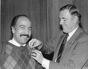 Mayor Raymond L. Flynn pinning a corsage on an unidentified man