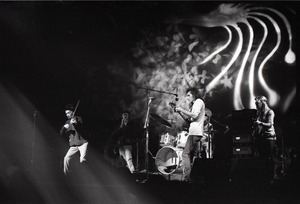 Hot Tuna concert: Band in performance on stage: Papa John Creach (violin), Will Scarlett (harmonica), Jorma Kaukonen (guitar), Jack Casady (bass) playing in front of light show