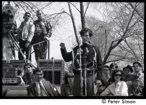 Resistance on the Boston Common: Terry Cannon (draft resister and member of the Oakland 7) addressing the crowd, Howard Zinn seated on stage (left)