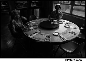 Two women seated at a table in the empty dining room during the one-day strike at Shelton Hall, Boston University