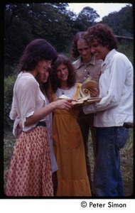 Peter Simon (right) looking over a book with commune members, Tree Frog Farm commune