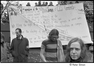 MIT war research demonstration: counter-protestors holding statement written on bed sheets,Lacey Mason in foreground