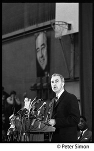 Presidential candidate Eugene McCarthy behind a bank of microphones giving a speech at Boston University