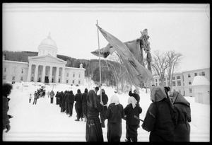 Protesters from Bread and Puppet Theater, dressed in cloaks and masks, unfurl a banner or puppet during a demonstration against the invasion of Laos at the Vermont State House