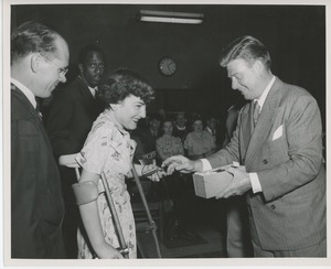 Arthur Godfrey presenting gift to client on crutches at Institute Day
