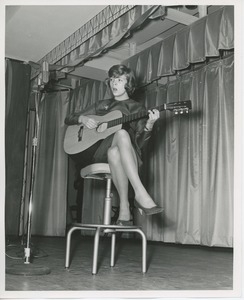 Young woman playing guitar at Thanksgiving celebration