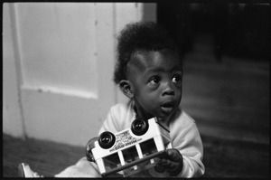 Che Swan as an infant, playing with a toy bus