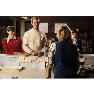 Family speaking to an employee at the front desk of the North Suburban YMCA