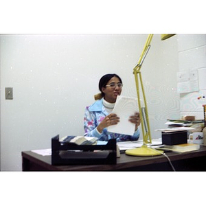 Female office worker seated behind desk at La Alianza Hispana, Boston