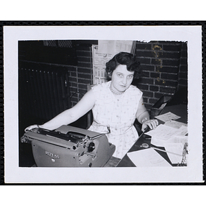 A female staff member sitting at a typewriter