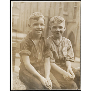 Two boys from the Boys' Clubs of Boston smiling for the camera while sitting outside