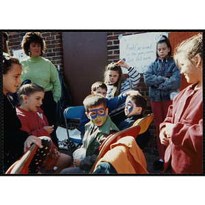 Childen with face paint pose at a carnival