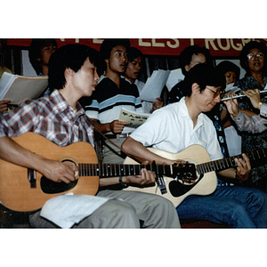 Guitarists play with a band and chorus at the Chinese Progressive Association's Fourth Anniversary Celebration