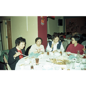 Suzanne Lee eats with other women while at a Chinese Progressive Association celebration of the Chinese New Year