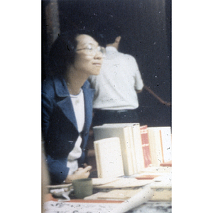 Suzanne Lee stands at an information booth for the Chinese Progressive Association