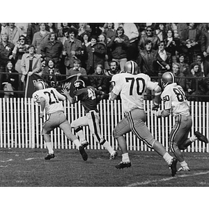 Kevin Foley, center, running from A.I.C. football players
