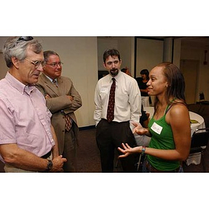 Melanie Arvajo speaks with three men at the Torch Scholars Orientation