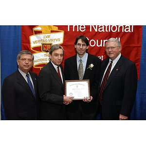 New inductee poses with certificate and three others at The National Council Dinner