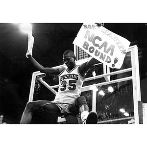 Reggie Lewis seated on basketball hoop