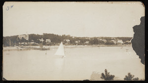 A view of the shoreline and a sailboat along the Cape Cod Canal