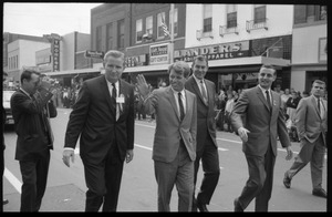 Robert F. Kennedy and entourage walking past Landers Ladies Apparel, during the Turkey Day festivities