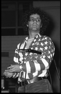 Abbie Hoffman in his American flag shirt, with yo yo in hand and whip under his arm