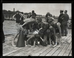 Children on a dock, gathering around a Graflex camera