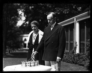 Calvin and Grace Coolidge in front of a house