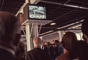 Bettors watch television displaying horse race