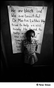 Young girl at the Liberation School, standing in front of a poster honoring Martin Luther King: 'We are black and beautiful. Dr. Martin Luther King tried to help us real nicely...'
